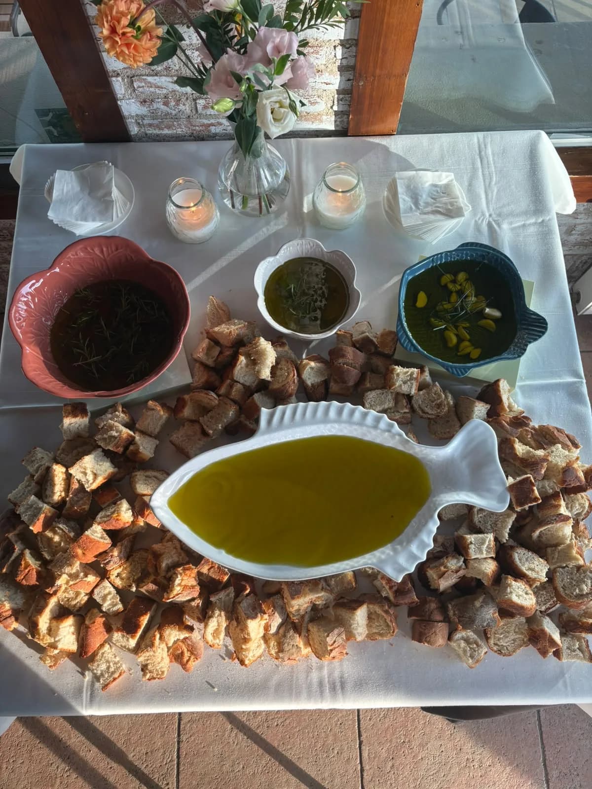 Mesa de aperitivos con aceite, panes y flores para una boda