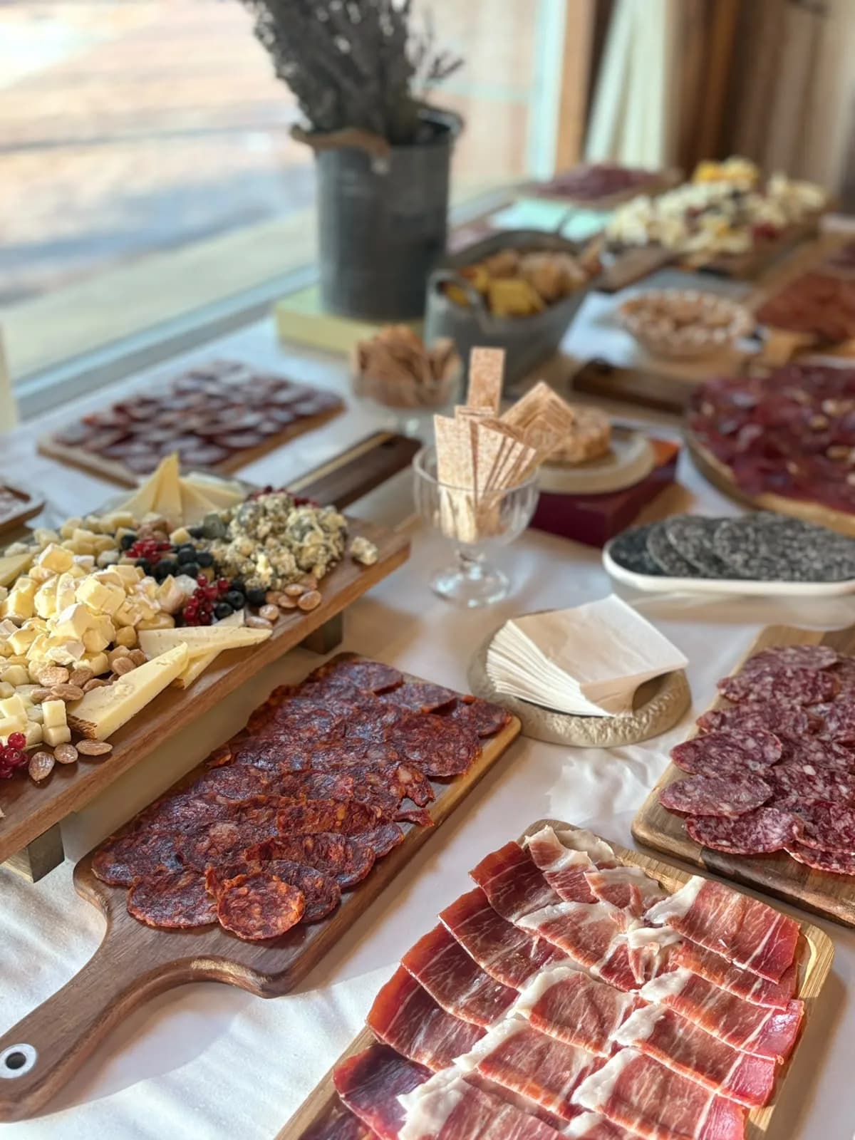 Mesa de catering con tablas de embutidos y quesos